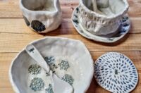 A pottery bowl and spoon, plate and jug