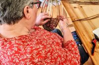 A lady weaving a willow plate