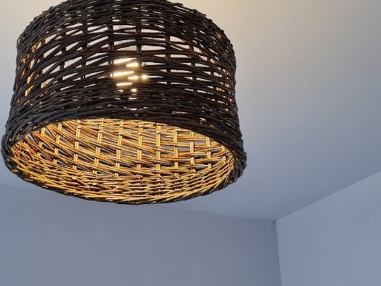 A lampshade made from willow on a weaving course